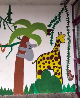 Ausschnitt der bemalten Wand, zu sehen sind unter anderem eine Palme, ein Koalabär und eine Giraffe.
