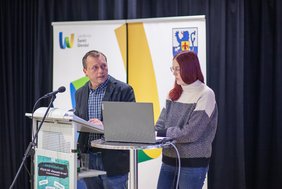 Zwei Personen stehen auf der Bühne und sprechen