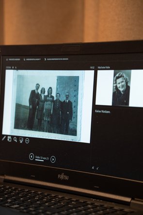 Aufnahme eines Laptopbildschirms, der eine Präsentation mit alten Fotos zeigt.