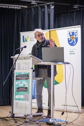 Prof. Dr. Fabian Virchow steht am Rednerpult und hält einen Vortrag.