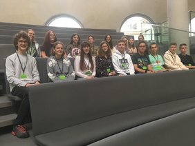 Mehrere junge Leute sitzen auf den Besucherplätzen.