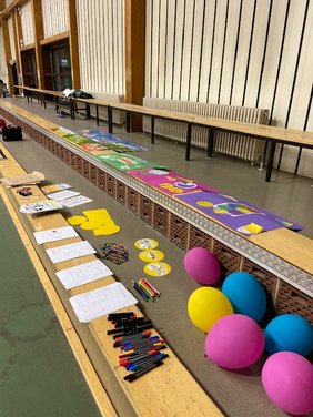 Luftballons, Stifte, Papier in einer Halle.