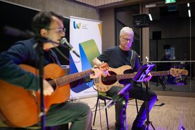 Die beiden Musiker der Band Brillant spielen sitzend.