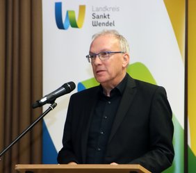 Landrat Udo Recktenwald am Rednerpult stehend.