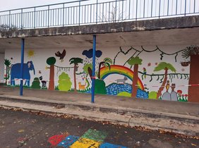 eine bunt bemalte Wand auf dem Schulhof.